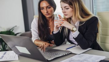 zwei Frauen arbeiten am PC Einladung Mitarbeiterbefragung