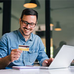 Mit dem Customer Effort Score den Kundenaufwand messen. Ein Man hält eine Kreditkarte in der Hand, während er online etwas bestellt.
