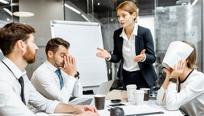 Mitarbeiterfluktuation hat viele Gründe. Eine Vorgesetze rügt ihre Angestellten in einem Meeting.