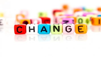 Ein paar bunte Würfel liegen nebeneinander und ergeben das Wort Change Management.