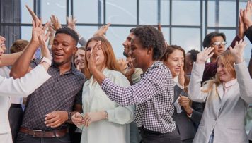 Gelebte erfolgreiche Employee Experience: Mitarbeitende feiern und jubeln zusammen.