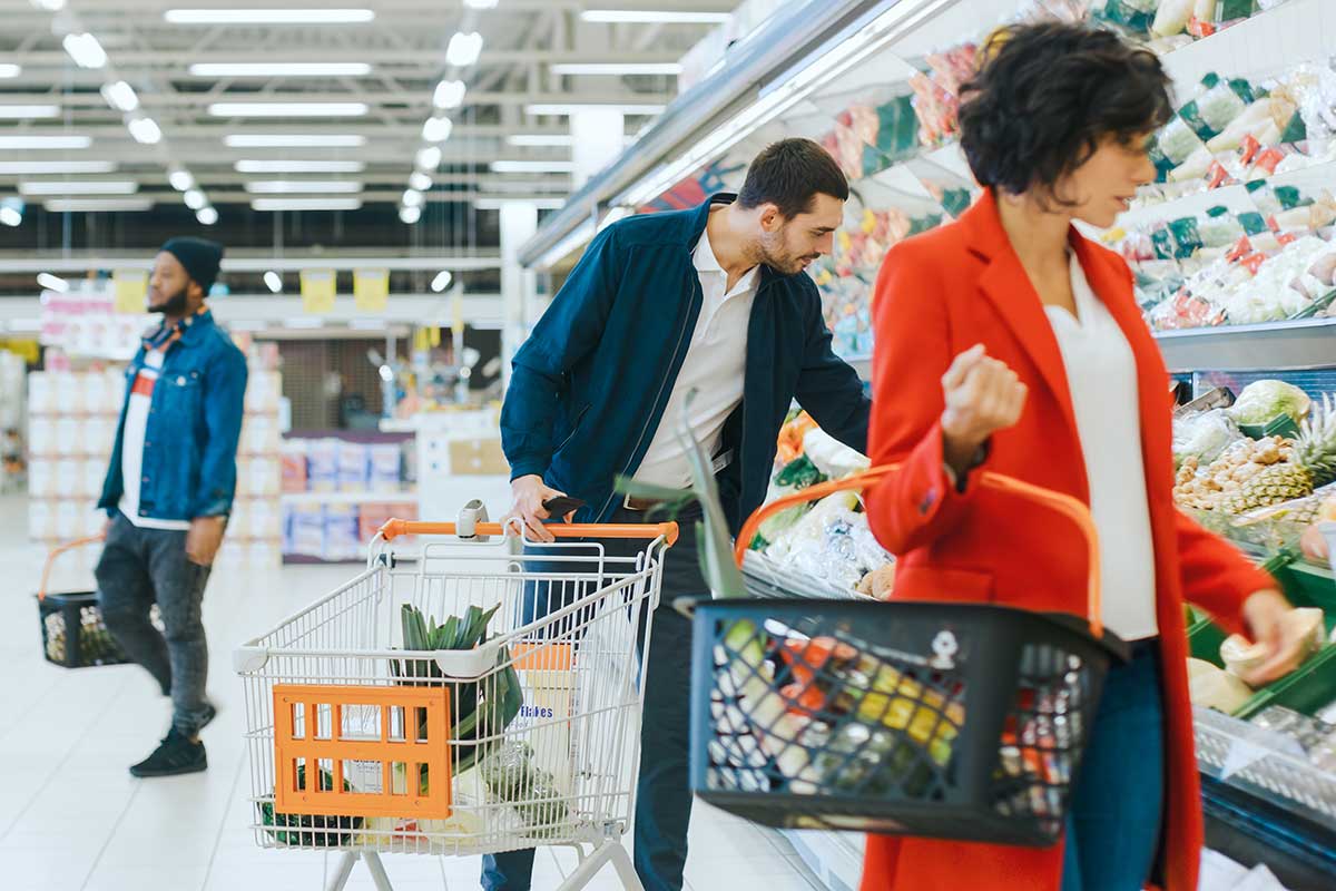 Menschen im Supermarkt suchen Lebensmittel, um anschließend B2C-Kundenfeedback abzugeben.