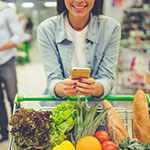 Mit dem NPSplus Kundenbegeisterung messen. Eine Frau steht mit einem vollem Einkaufswagen im Supermarkt.