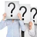 Wichtige Fragen im Mitarbeiterfeedback klären. Mitarbeitende halten Fragezeichen vor ihre Gesichter.