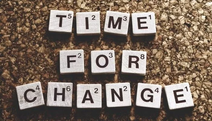 Ein paar Steine mit Buchstaben liegen nebeneinander und ergeben das Wort time for Change Management.